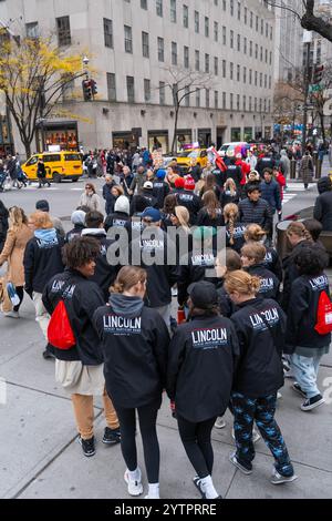 Folle di turisti e newyorkesi che camminano lungo la Fifth Avenue durante il Black Friday l'inizio non ufficiale della stagione dello shopping natalizio a New York . Città. Studenti delle scuole superiori di Lincoln HS di Souix Falls, South Dakota, in città. Foto Stock