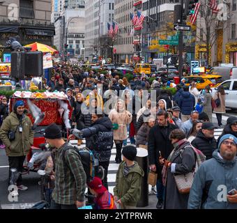 Folle di turisti e newyorkesi che camminano lungo la Fifth Avenue durante il Black Friday l'inizio non ufficiale della stagione dello shopping natalizio a New York City. Foto Stock