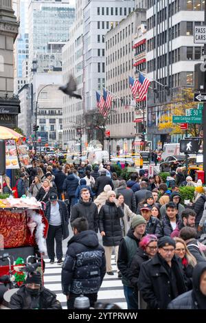 Folle di turisti e newyorkesi che camminano lungo la Fifth Avenue durante il Black Friday l'inizio non ufficiale della stagione dello shopping natalizio a New York City. Foto Stock