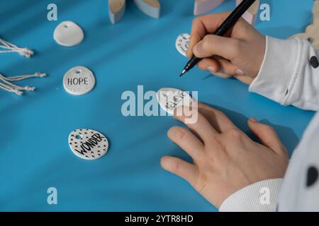 Workshop che scrivono "BELIEVE on EASTER Creatore di argilla uovo di PASQUA" utilizza l'argilla secca bianca per creare decorazioni per le vacanze DI PASQUA. Creazione di attività ricreative hobby che coinvolgono le dita. Fai da te per creare arte moderna Foto Stock