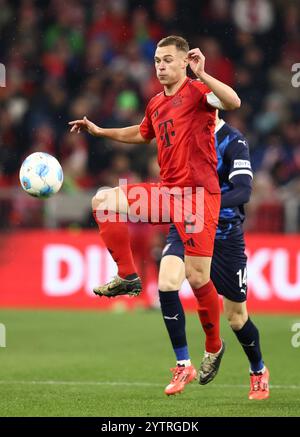 MONACO DI BAVIERA, GERMANIA - 07 DICEMBRE: Joshua Kimmich del Bayern Muenchen corre con un pallone Maxilmilian Breunig del FC Heidenheim durante la partita di Bundesliga tra FC Bayern München e 1. FC Heidenheim 1846 all'Allianz Arena il 7 dicembre 2024 a Monaco, Germania. © diebilderwelt / Alamy Stock Foto Stock