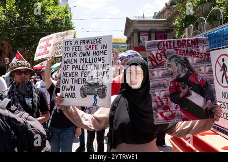 I manifestanti espongono cartelli ad un raduno pro palestinese a Melbourne, Victoria, Australia. Foto Stock