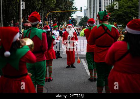 Bogotà, Colombia. 7 dicembre 2024. Gli artisti partecipano a una sfilata natalizia vestita da Babbo Natale e elfi il 7 dicembre 2024 a Bogotà, Colombia. La gente in Colombia celebra l'inizio della stagione natalizia celebrando una notte che accende le candele come tradizione. Foto di: Sebastian Barros/Long Visual Press credito: Long Visual Press/Alamy Live News Foto Stock