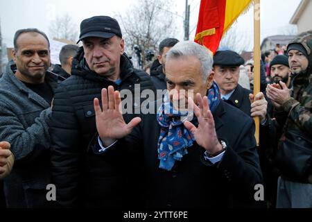 Mogosoaia, Romania. 8 dicembre 2024. Calin Georgescu (front), vincitore del primo turno delle elezioni presidenziali in Romania, gesti dopo aver parlato con i media di fronte a un seggio elettorale chiuso a Mogosoaia, vicino Bucarest, Romania, 8 dicembre 2024. Il candidato presidenziale indipendente Calin Georgescu ha invitato l'Ufficio elettorale centrale (BEC) e l'Autorità elettorale permanente (AEP) della Romania a ignorare la decisione della Corte costituzionale (CCR) che ha annullato le elezioni presidenziali e a consentire il proseguimento del processo di voto. Crediti: Cristian Cristel/Xinhua/Alamy Live News Foto Stock