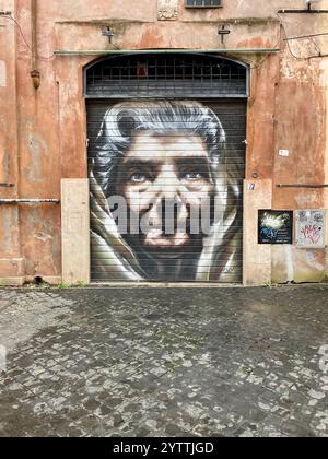 Un ritratto di uno spray facciale di una donna anziana dipinto su una porta con persiane di metallo dall'artista di strada neve nella zona di Trastevere a Roma Foto Stock