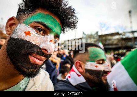 8 dicembre 2024, Renania settentrionale-Vestfalia, Wuppertal: Durante una manifestazione a Wuppertal, un uomo ha dipinto la bandiera siriana sul suo volto. Foto: Christoph Reichwein/dpa Foto Stock