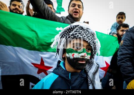 8 dicembre 2024, Renania settentrionale-Vestfalia, Wuppertal: Un ragazzo con la bandiera siriana dipinta sul viso e una sciarpa palestinese intorno alla testa. La gente celebra la caduta del regime di Assad in Siria. Foto: Christoph Reichwein/dpa Foto Stock