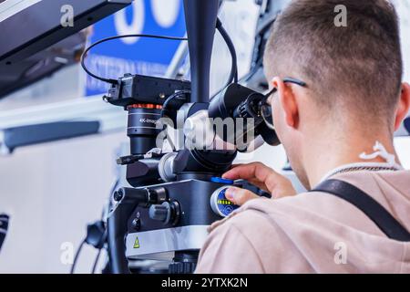 Un uomo guarda nel binocolo di un microscopio dentale Foto Stock