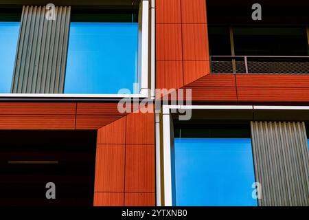 Edificio moderno con pannelli rossi e bianchi e finestre riflettenti in vetro Foto Stock