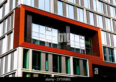 Edificio moderno con pannelli rossi e bianchi e finestre riflettenti in vetro Foto Stock
