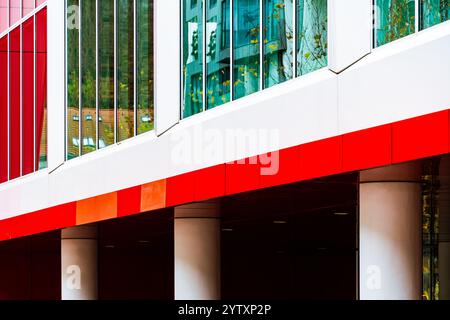 Edificio moderno con pannelli rossi e bianchi e finestre riflettenti in vetro Foto Stock