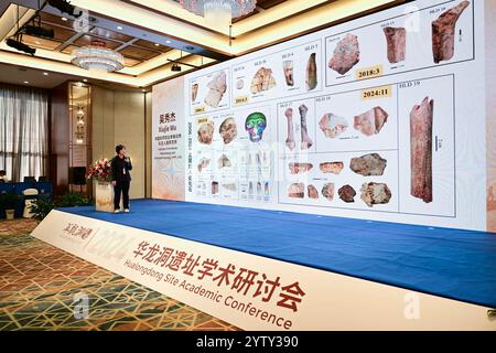 (241208) -- CHIZHOU, 8 dicembre 2024 (Xinhua) -- Wu Xiujie, ricercatore presso l'Institute of Vertebrate Paleontology and Paleoanthropology of the Chinese Academy of Sciences, introduce le ultime scoperte e studi riguardanti l'antico sito umano di Hualongdong durante la conferenza accademica sul sito di Hualongdong nella contea di Dongzhi della città di Chizhou, nella provincia di Anhui, nella Cina orientale, 6 dicembre 2024. Gli scienziati cinesi hanno scoperto dozzine di fossili umani risalenti a 300.000 anni fa, che sono i primi trovati in Asia orientale in termini di processo di evoluzione verso l'Homo sapiens, la specie a cui si riferisce Foto Stock