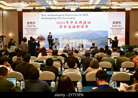 (241208) -- CHIZHOU, 8 dicembre 2024 (Xinhua) -- Wu Xiujie, ricercatore presso l'Institute of Vertebrate Paleontology and Paleoanthropology of the Chinese Academy of Sciences, introduce le ultime scoperte e studi riguardanti l'antico sito umano di Hualongdong durante la conferenza accademica sul sito di Hualongdong nella contea di Dongzhi della città di Chizhou, nella provincia di Anhui, nella Cina orientale, 6 dicembre 2024. Gli scienziati cinesi hanno scoperto dozzine di fossili umani risalenti a 300.000 anni fa, che sono i primi trovati in Asia orientale in termini di processo di evoluzione verso l'Homo sapiens, la specie a cui si riferisce Foto Stock