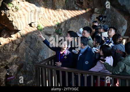 (241208) -- CHIZHOU, 8 dicembre 2024 (Xinhua) -- Wu Xiujie (1° L, fronte), ricercatore presso l'Istituto di Paleontologia dei vertebrati e Paleoantropologia dell'Accademia cinese delle scienze, introduce il sito di Hualongdong ai visitatori del sito nella contea di Dongzhi della città di Chizhou, nella provincia di Anhui della Cina orientale, 6 dicembre 2024. Gli scienziati cinesi hanno scoperto dozzine di fossili umani risalenti a 300.000 anni fa, che sono i primi trovati in Asia orientale in termini di processo di evoluzione verso l'Homo sapiens, la specie a cui appartengono tutti gli esseri umani moderni. I fossili umani, insieme a un grosso Foto Stock