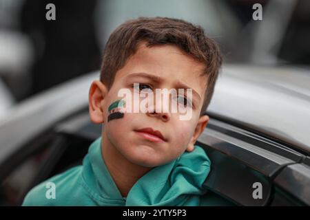 Ankara, Turchia. 8 dicembre 2024. Un ragazzo siriano con la nuova bandiera siriana dipinta sul suo volto prende parte alle celebrazioni di strada. Rifugiati siriani che vivevano nel quartiere di Önder, Ankara scese in strada per celebrare il rovesciamento di Bashar al-Assad. Credito: SOPA Images Limited/Alamy Live News Foto Stock