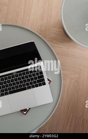 Un accogliente ambiente di lavoro libero su un tavolo verde rotondo in un interno minimalista e luminoso della casa. Foto Stock