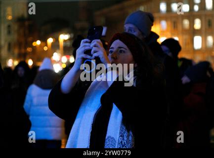 Non esclusiva: KIEV, UCRAINA - 6 DICEMBRE 2024 - Una donna scatta foto del principale albero di Natale dell'Ucraina durante la cerimonia di illuminazione a Sofiisk Foto Stock