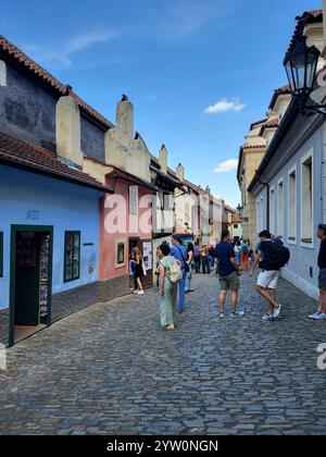 Turisti che passeggiano lungo Una pittoresca e affascinante strada acciottolata europea Foto Stock