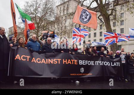 Londra, Regno Unito. 8 dicembre 2024. I manifestanti marciano con uno striscione che recita "agire contro l'odio prima che sia troppo tardi" durante la manifestazione a Whitehall. Migliaia di persone hanno marciato nel centro di Londra contro l'antisemitismo e a sostegno di Israele mentre Israele continua i suoi attacchi a Gaza. Credito: SOPA Images Limited/Alamy Live News Foto Stock