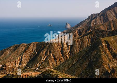Un paesaggio costiero mozzafiato caratterizzato da scogliere aspre, onde oceaniche e un sereno orizzonte blu sotto un cielo limpido. Foto Stock