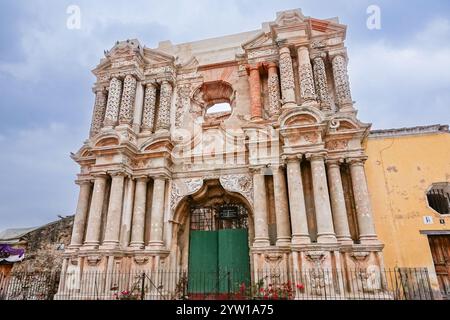 Facciata esterna delle rovine della Iglesia de Nuestra Señora de El Carmen, o la Chiesa di nostra Signora di Carmen, una chiesa cattolica ornata distrutta dai terremoti di Santa Marta del 1773 ad Antigua, Guatemala. Un mercato settimanale dell'artigianato si svolge spesso fuori dalle rovine. Foto Stock