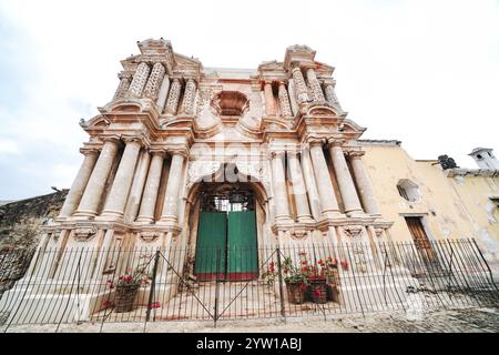 Facciata esterna delle rovine della Iglesia de Nuestra Señora de El Carmen, o la Chiesa di nostra Signora di Carmen, una chiesa cattolica ornata distrutta dai terremoti di Santa Marta del 1773 ad Antigua, Guatemala. Un mercato settimanale dell'artigianato si svolge spesso fuori dalle rovine. Foto Stock