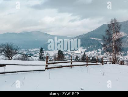 Lo spuntar del giorno mattina inverno tramonto dei Carpazi villaggio di montagna Zelene in nero Cheremosh river valley tra alp. Vista dalla campagna coperta di neve percorso sulla collina Foto Stock