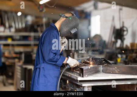 Durante la fabbricazione del prodotto, il dipendente MAN lavora con una saldatrice Foto Stock