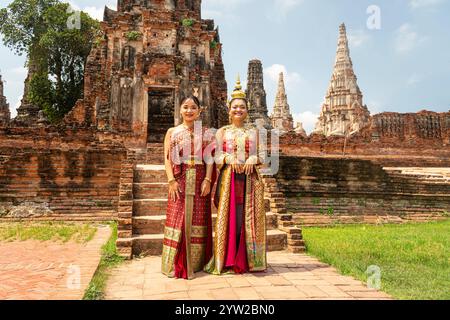 Giovani donne asiatiche in abiti tradizionali thailandesi contro le rovine di Ayutthaya, l'antica capitale del regno del Siam. Ayutthaya, Thailandia maggio 30, Foto Stock