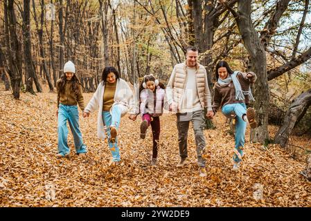 Ritratto di famiglia multigenerazionale. Genitori, nonna e figlie a piedi nella foresta. Foto Stock