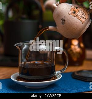Una tradizionale preparazione del tè con una pentola splendidamente lavorata e un'elegante tazza di vetro, perfetta per gli amanti del tè Foto Stock