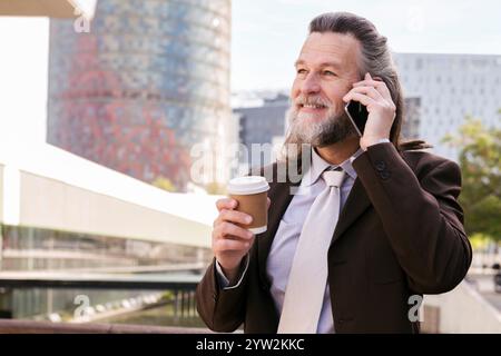 Sorridente uomo maturo parlando al telefono cellulare Foto Stock