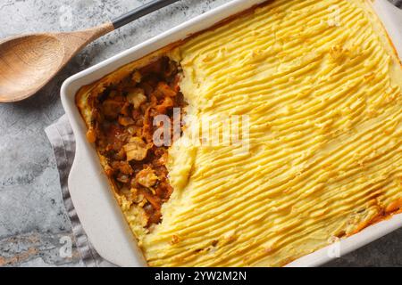 Torta di pastori senza carne ai funghi senza lenticchie, cipolle, pomodori, carote da primo piano in un piatto da forno sul tavolo. Vista dall'alto orizzontale da Foto Stock