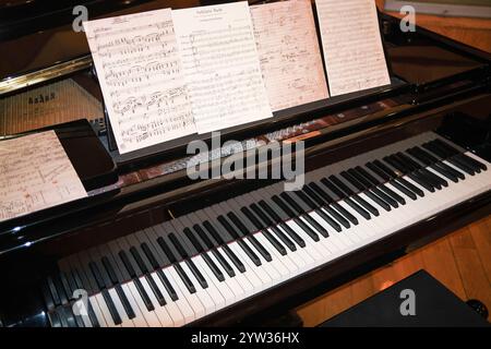 Un pianoforte a coda con spartiti sul palco pronto a suonare un musicista. Foto Stock