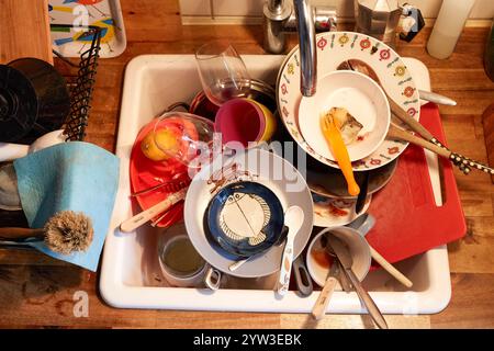 Un lavandino pieno di piatti sporchi, tra cui tazze, piatti e utensili con residui alimentari, Germania Foto Stock