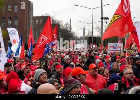 Wolfsburg, Germania. 9 dicembre 2024. I dipendenti protestano con uno sciopero di avvertimento organizzato da IG Metall di fronte alla sede centrale della casa automobilistica Volkswagen a Wolfsburg. Credito: Martin Meissner/AP POOL/dpa/Alamy Live News Foto Stock