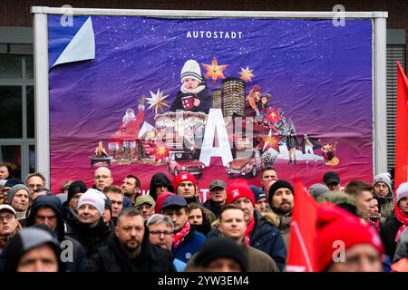 Wolfsburg, Germania. 9 dicembre 2024. I dipendenti protestano con uno sciopero di avvertimento organizzato da IG Metall di fronte alla sede centrale della casa automobilistica Volkswagen a Wolfsburg. Credito: Martin Meissner/AP POOL/dpa/Alamy Live News Foto Stock
