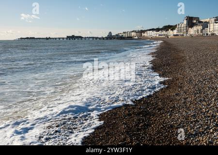 Onde che si infrangono sulla spiaggia di ciottoli con Hastings Pier dietro, Hastings, East Sussex, Inghilterra, Regno Unito, Europa Foto Stock