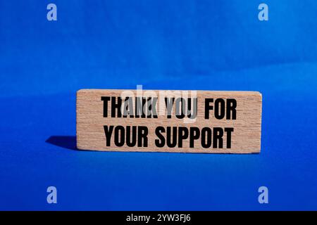 Grazie per il messaggio di supporto scritto su un blocco di legno con sfondo blu. Grazie concettuale per il vostro simbolo di supporto. Copia spazio. Foto Stock