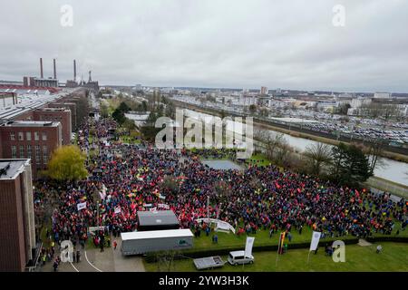 Wolfsburg, Germania. 9 dicembre 2024. I partecipanti allo sciopero di avvertimento IG Metall si trovano di fronte alla sede centrale della casa automobilistica Volkswagen a Wolfsburg. Credito: Martin Meissner/AP POOL/dpa/Alamy Live News Foto Stock