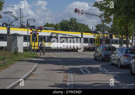 Treno regionale che attraversa un passaggio a livello con barriere, Riegel am Kaiserstuhl, Baden-Wuerttemberg, Germania, Europa Foto Stock