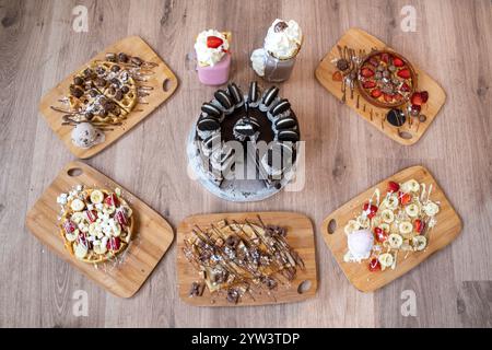 Dessert selezionati, tra cui crepe di fragole e banana, pasta per biscotti, waffle al cioccolato e frullati Foto Stock