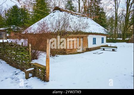 La passeggiata invernale a Pereiaslav Scansen con una vista della tradizionale casa di hata in legno-argilla, Ucraina Foto Stock