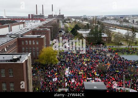Wolfsburg, Germania. 9 dicembre 2024. I partecipanti allo sciopero di avvertimento IG Metall si trovano di fronte alla sede centrale della casa automobilistica Volkswagen a Wolfsburg. Credito: Martin Meissner/AP POOL/dpa/Alamy Live News Foto Stock