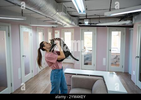 Il personale di una donna in un hotel di animali coccola il gatto per alleviare lo stress, offrendo affetto per prevenire la solitudine Foto Stock