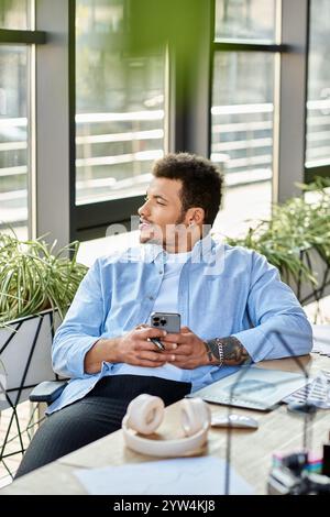 Un uomo elegante ama trascorrere un momento di svago in un ufficio luminoso pieno di piante. Foto Stock