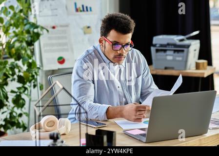 Un uomo dedicato valuta documenti importanti mentre lavora in un ufficio creativo pieno di piante. Foto Stock