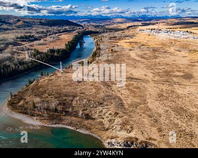 Gasdotto che attraversa il fiume lasciando un sito industriale distante che trasporta risorse naturali che si affaccia sul Canadian Rocky MoU Foto Stock
