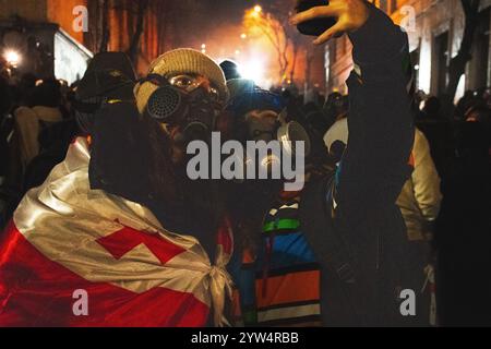 Tbilisi, Georgia - 1 dicembre 2024: Le giovani ragazze stanno con le bandiere UE e georgiane del parlamento. Il raduno su Rustaveli Avenue, lo slogan della ral Foto Stock