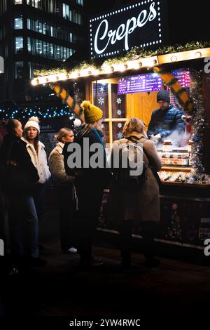 CITY SQUARE, LEEDS, REGNO UNITO - 28 NOVEMBRE 2024. Una colorata bancarella di mercatini che vende crepes agli acquirenti al mercato di Natale di Leeds in City Square, Leeds, Foto Stock